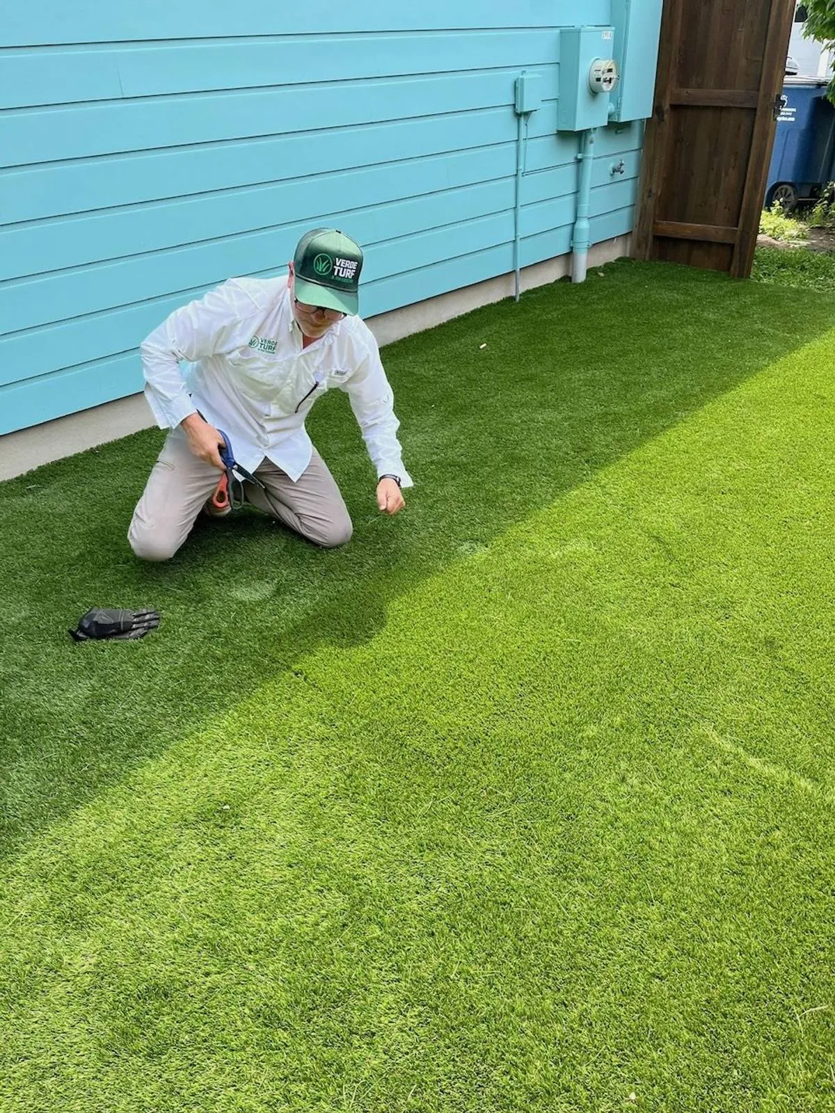 Installer checking a freshly laid artificial turf seam