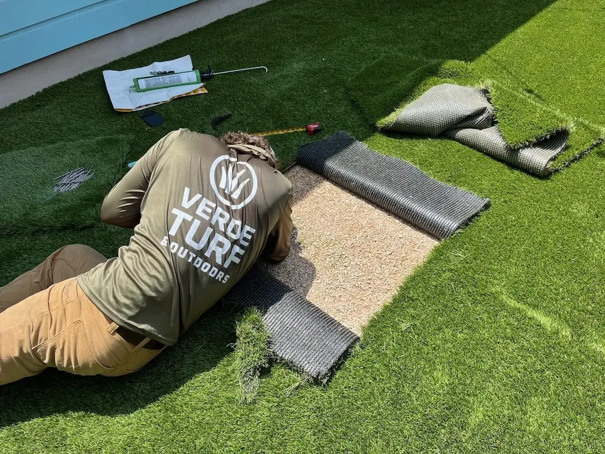 Installer gluing an artificial turf seam
